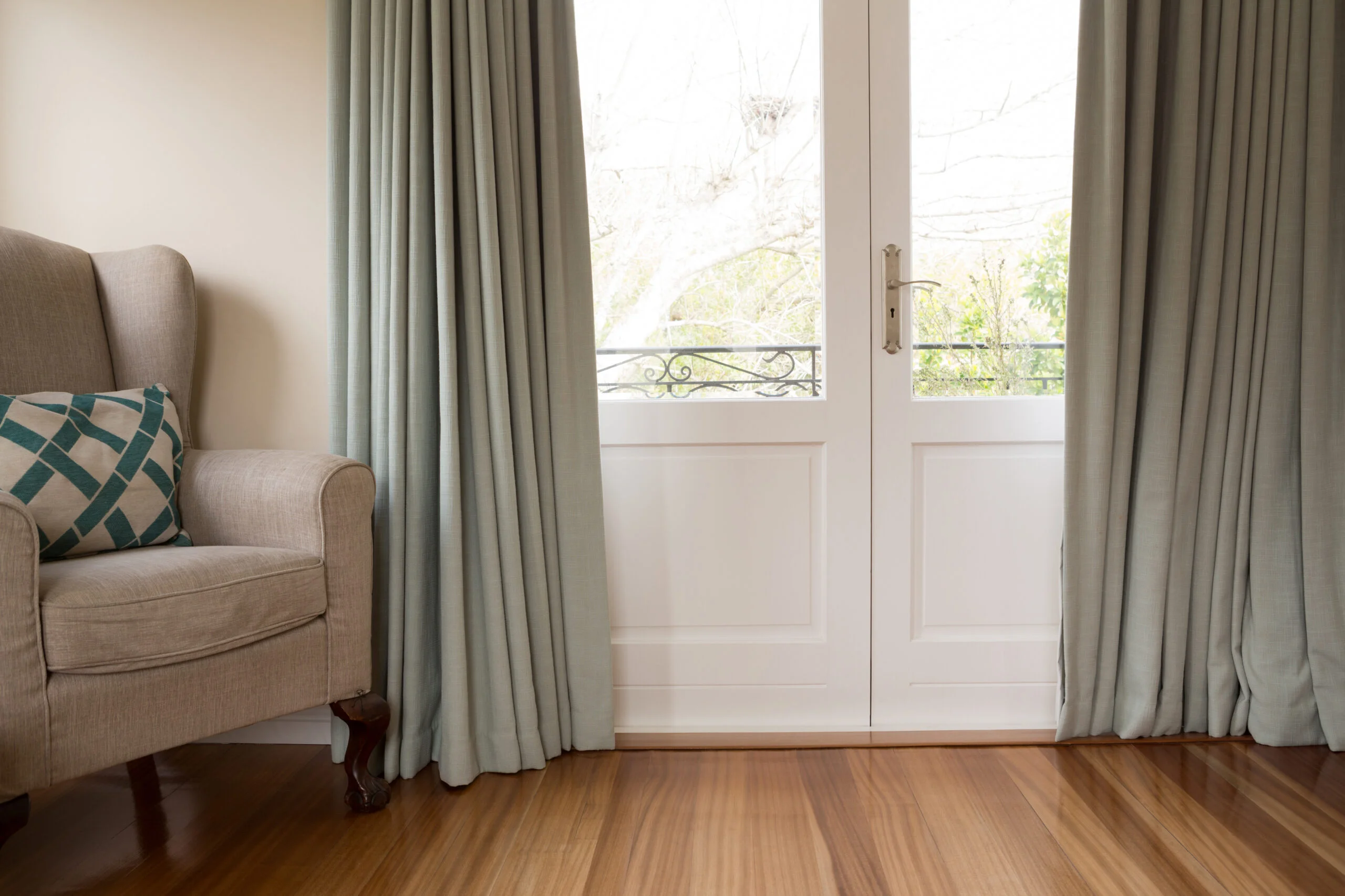 Closed door with sofa on wooden floor in living room at home